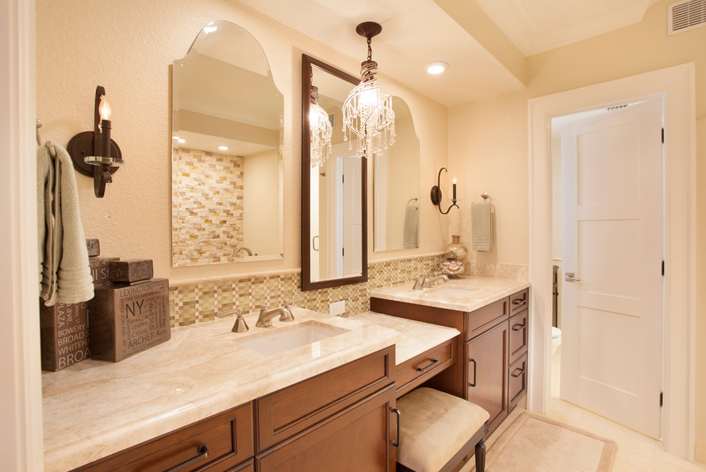 Design ideas for a mid-sized tropical master bathroom in Miami with flat-panel cabinets, medium wood cabinets, a freestanding tub, a corner shower, a two-piece toilet, beige tile, stone tile, beige walls, travertine floors, an undermount sink and marble benchtops.