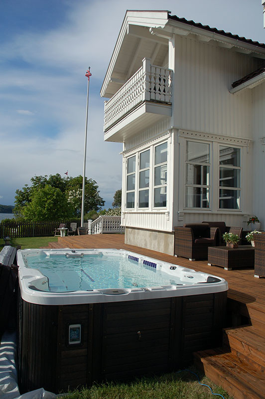 Photo of a mid-sized traditional backyard rectangular aboveground pool in Orange County with a hot tub and decking.
