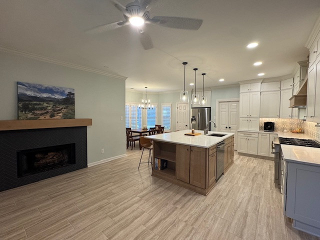 Example of a mid-sized transitional l-shaped porcelain tile and beige floor eat-in kitchen design with recessed-panel cabinets, white cabinets, quartz countertops, beige backsplash, porcelain backsplash, stainless steel appliances, an island and white countertops