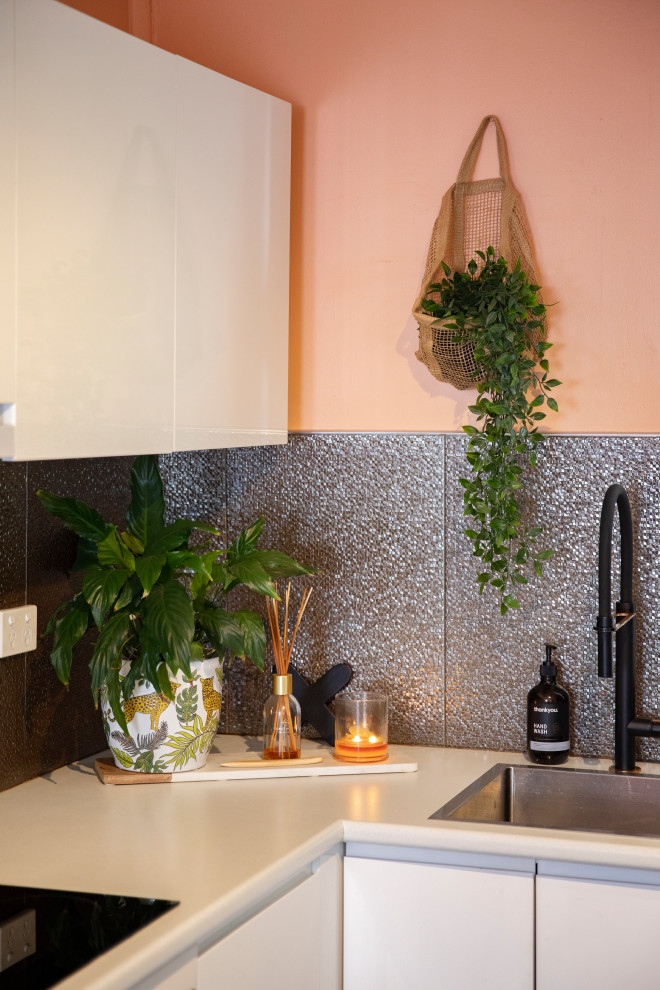 Design ideas for a mid-sized mediterranean l-shaped open plan kitchen in Newcastle - Maitland with a drop-in sink, white cabinets, laminate benchtops, metallic splashback, ceramic splashback, stainless steel appliances, dark hardwood floors, with island, brown floor and white benchtop.