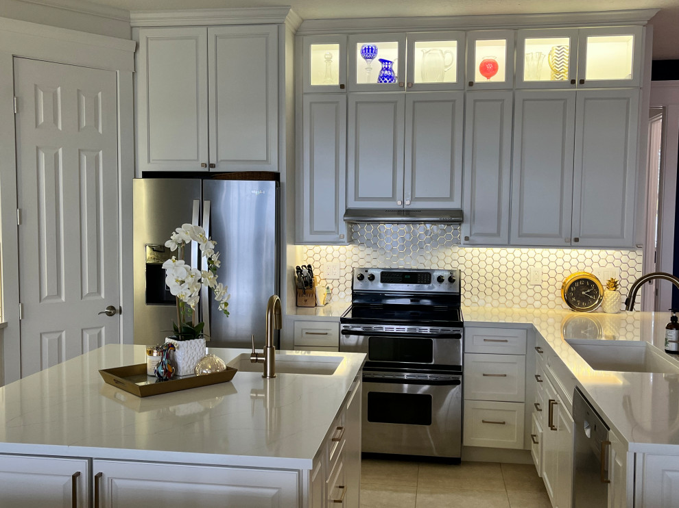 Mid-sized transitional u-shaped eat-in kitchen photo with an undermount sink, raised-panel cabinets, white cabinets, quartz countertops, multicolored backsplash, mosaic tile backsplash, stainless steel appliances, an island and multicolored countertops