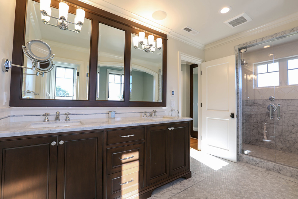 Design ideas for a large traditional master bathroom in San Francisco with beaded inset cabinets, dark wood cabinets, a freestanding tub, a double shower, a one-piece toilet, white tile, ceramic tile, white walls, marble floors, an undermount sink and marble benchtops.