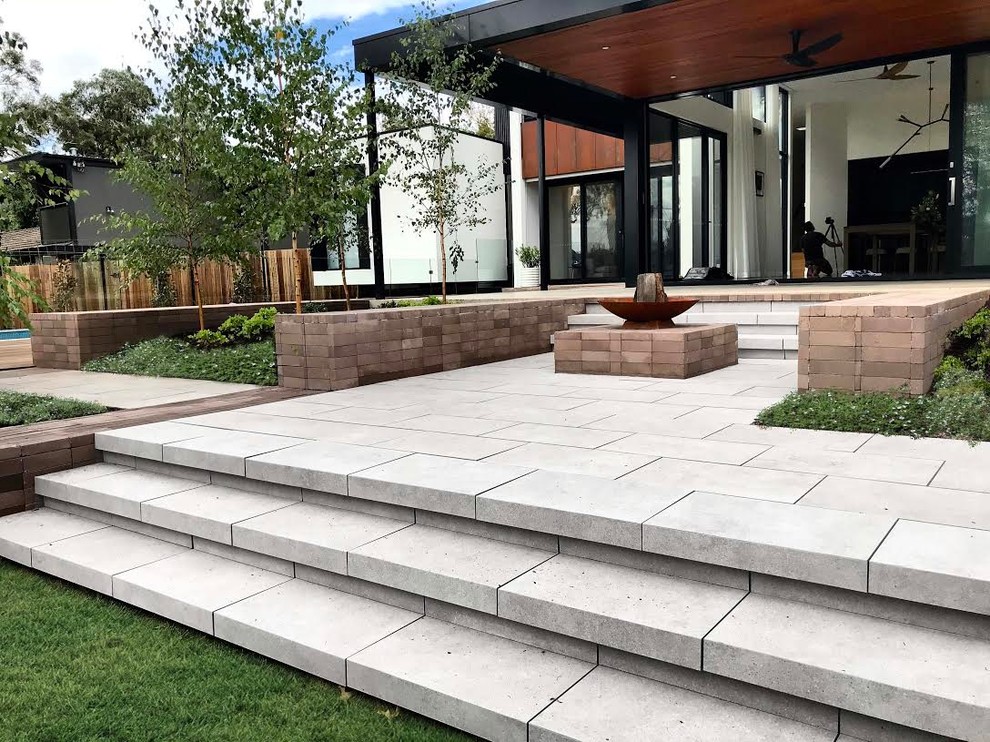 Photo of a large modern backyard patio in Canberra - Queanbeyan with a fire feature and brick pavers.