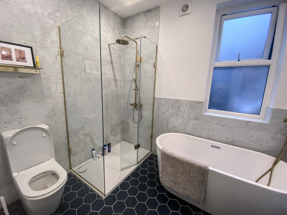 Photo of a medium sized contemporary family bathroom in Oxfordshire with a freestanding bath, a walk-in shower, grey tiles, marble tiles, white walls, mosaic tile flooring, blue floors, an open shower and a single sink.
