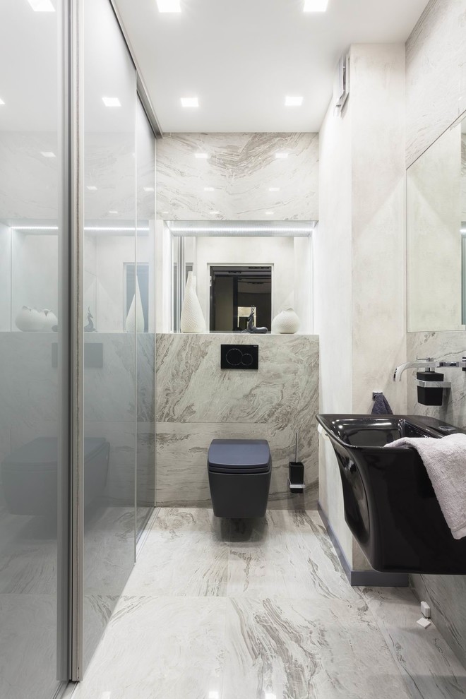 Photo of a contemporary powder room in Other with a wall-mount toilet, gray tile, a wall-mount sink and grey floor.
