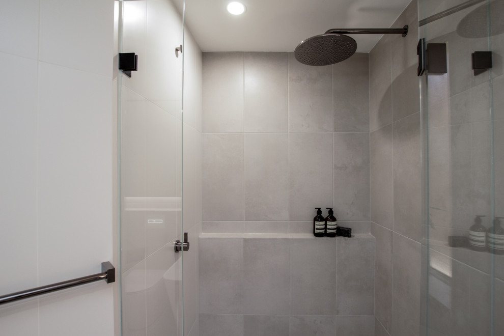 Large modern master bathroom in Sydney with an alcove shower, a one-piece toilet, gray tile, grey walls, a wall-mount sink, grey floor, a hinged shower door, a single vanity and a built-in vanity.