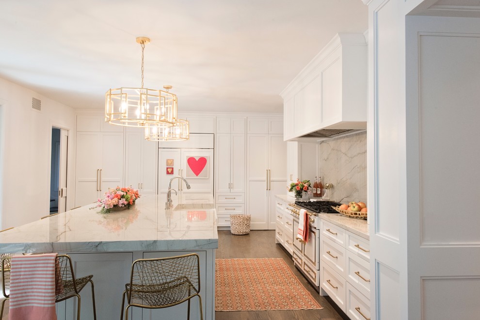 Inspiration for a large transitional l-shaped medium tone wood floor and brown floor open concept kitchen remodel with a farmhouse sink, recessed-panel cabinets, white cabinets, quartzite countertops, white backsplash, stone slab backsplash, paneled appliances and an island