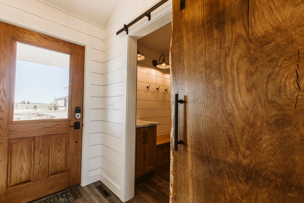 Photo of a mid-sized country front door in Other with white walls, vinyl floors, a single front door, a medium wood front door and brown floor.