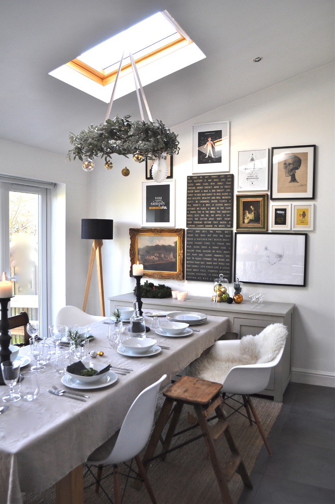 This is an example of an eclectic dining room in London with white walls.