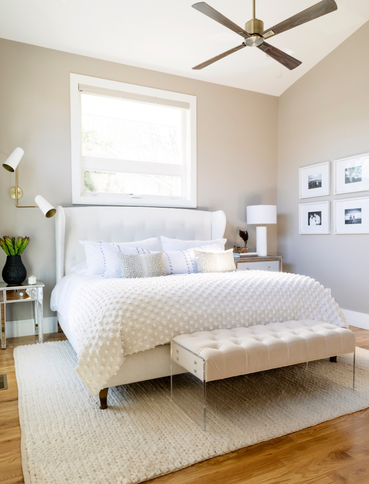 Modernes Hauptschlafzimmer mit beiger Wandfarbe, braunem Holzboden und gewölbter Decke in Sonstige