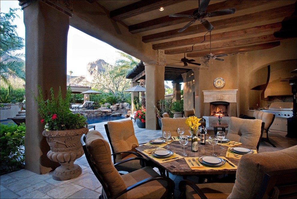 Design ideas for a large backyard patio in Phoenix with a water feature, natural stone pavers and a roof extension.