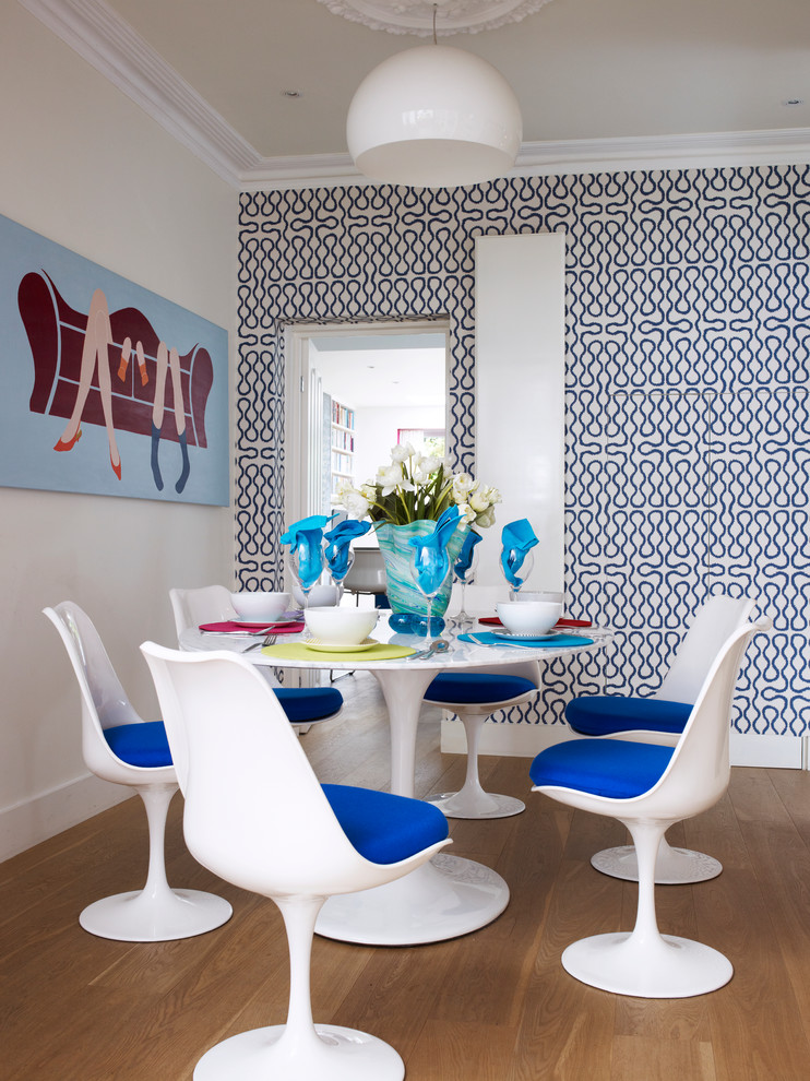 Photo of a small contemporary separate dining room in London with multi-coloured walls and medium hardwood floors.