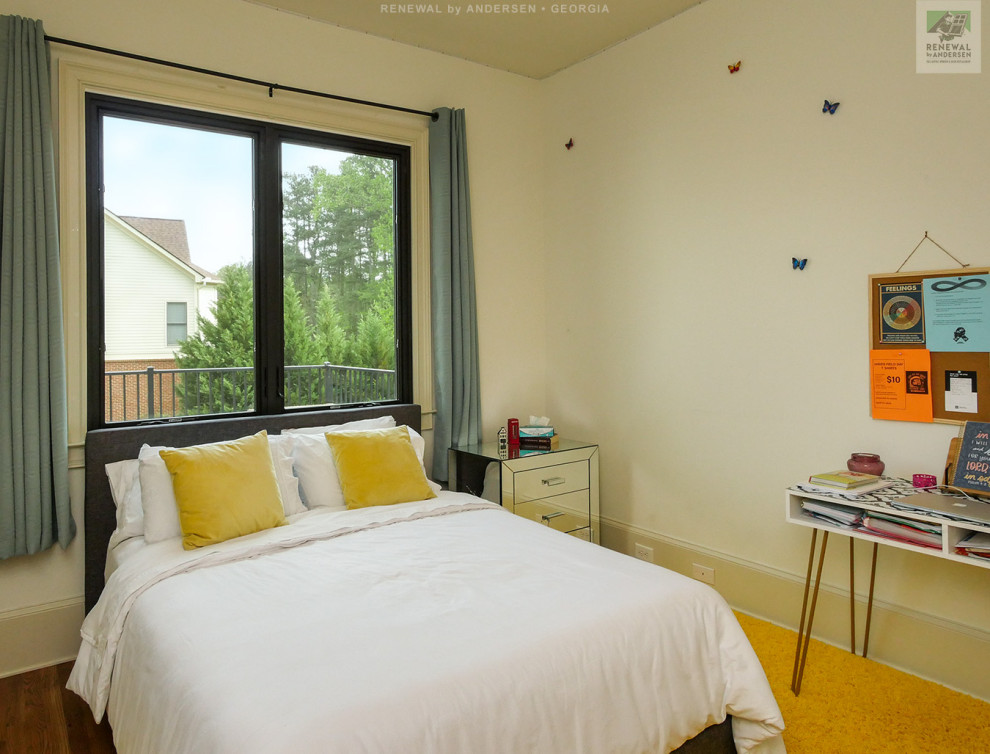 Bild på ett mellanstort barnrum kombinerat med sovrum, med beige väggar, heltäckningsmatta och orange golv