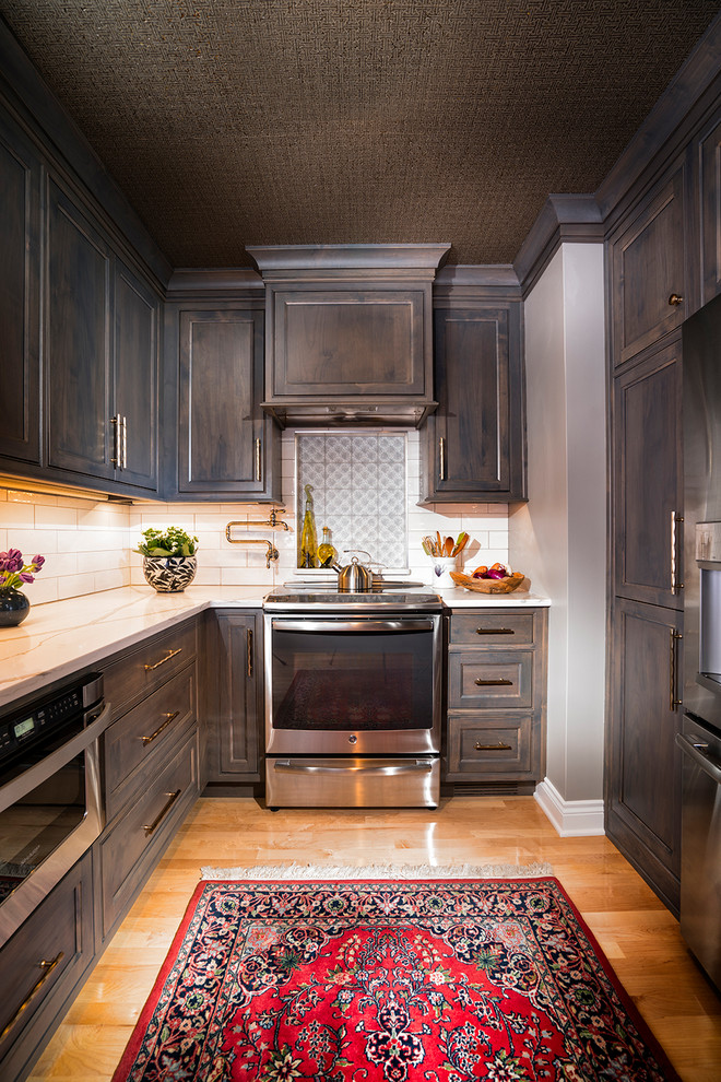 Transitional light wood floor kitchen photo with a farmhouse sink, gray cabinets, quartz countertops, white backsplash, subway tile backsplash and stainless steel appliances
