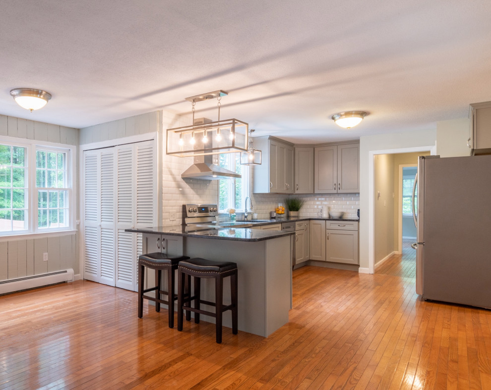 Transitional eat-in kitchen photo in Boston with granite countertops, white backsplash, ceramic backsplash, an island, gray cabinets and gray countertops