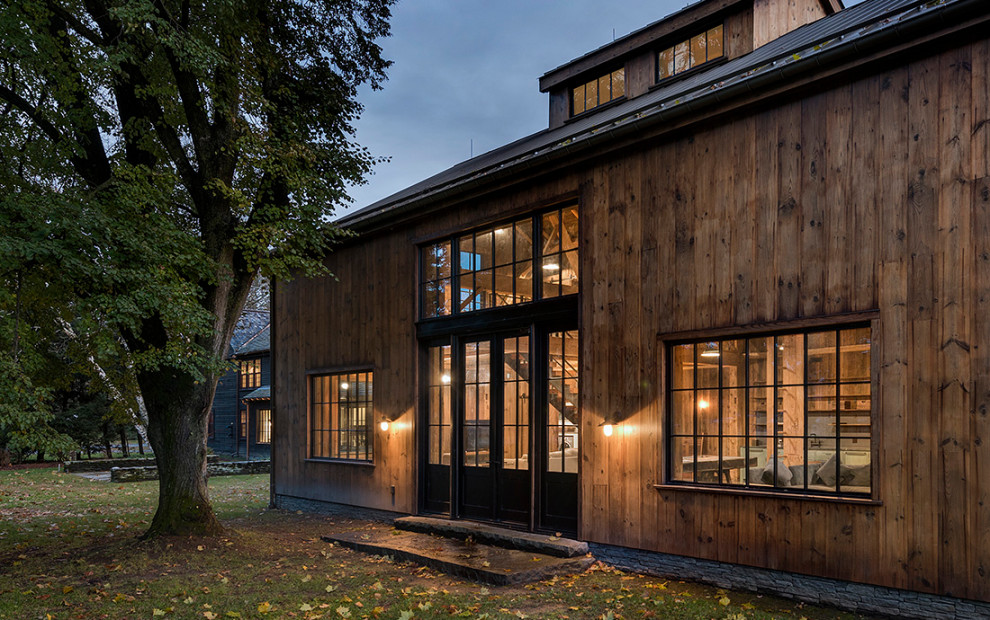This is an example of an expansive country two-storey exterior in Boston with wood siding and board and batten siding.
