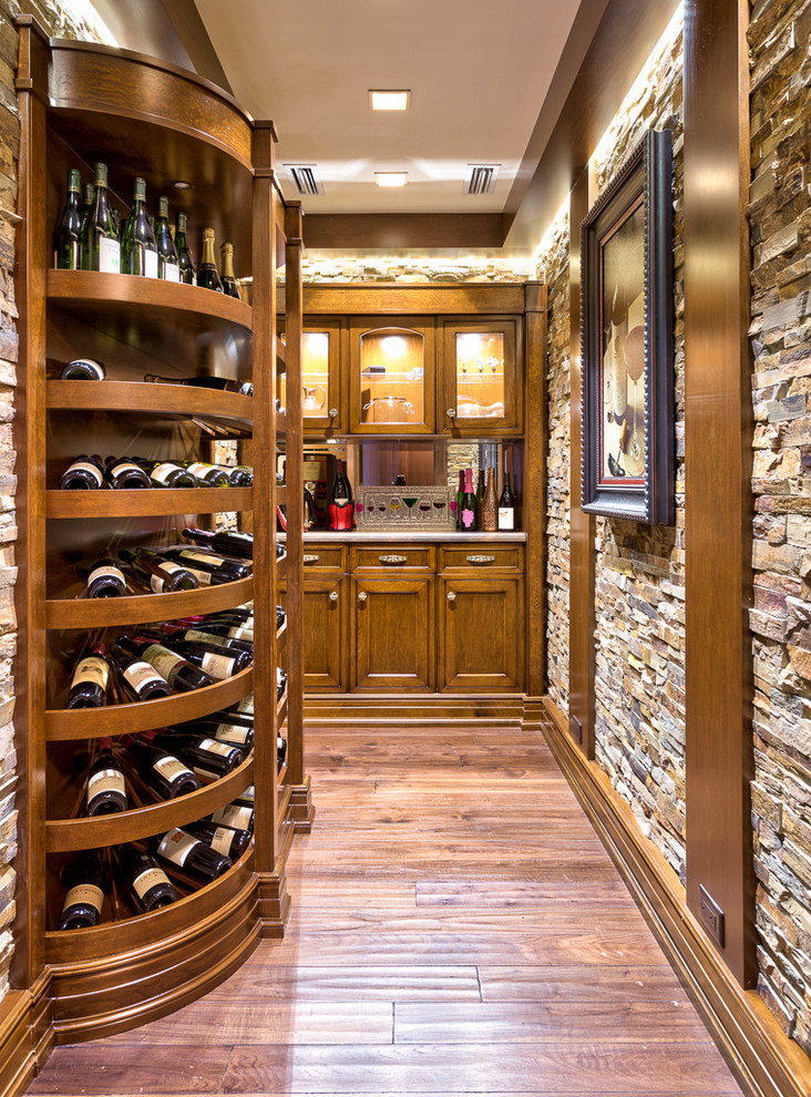 Country wine cellar in Other with medium hardwood floors and display racks.