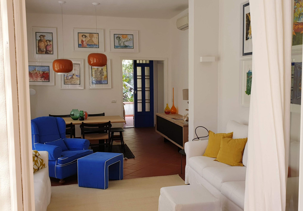 Источник вдохновения для домашнего уюта: изолированная гостиная комната среднего размера в современном стиле с белыми стенами, кирпичным полом, телевизором на стене и коричневым полом