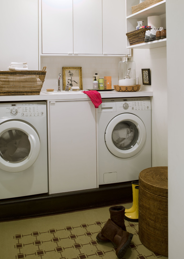 Contemporary laundry room in New York with white cabinets.