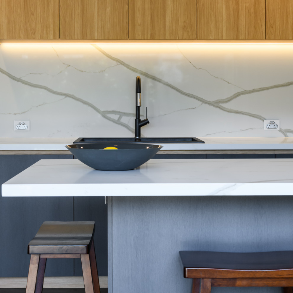Photo of a mid-sized contemporary l-shaped kitchen in Melbourne with flat-panel cabinets, marble benchtops and marble splashback.