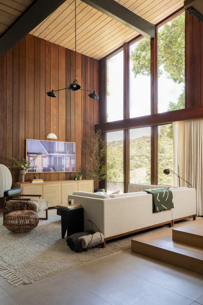 Cette photo montre un salon rétro en bois de taille moyenne et ouvert avec un mur marron, un sol en carrelage de porcelaine, un téléviseur fixé au mur, un sol beige et un plafond en bois.