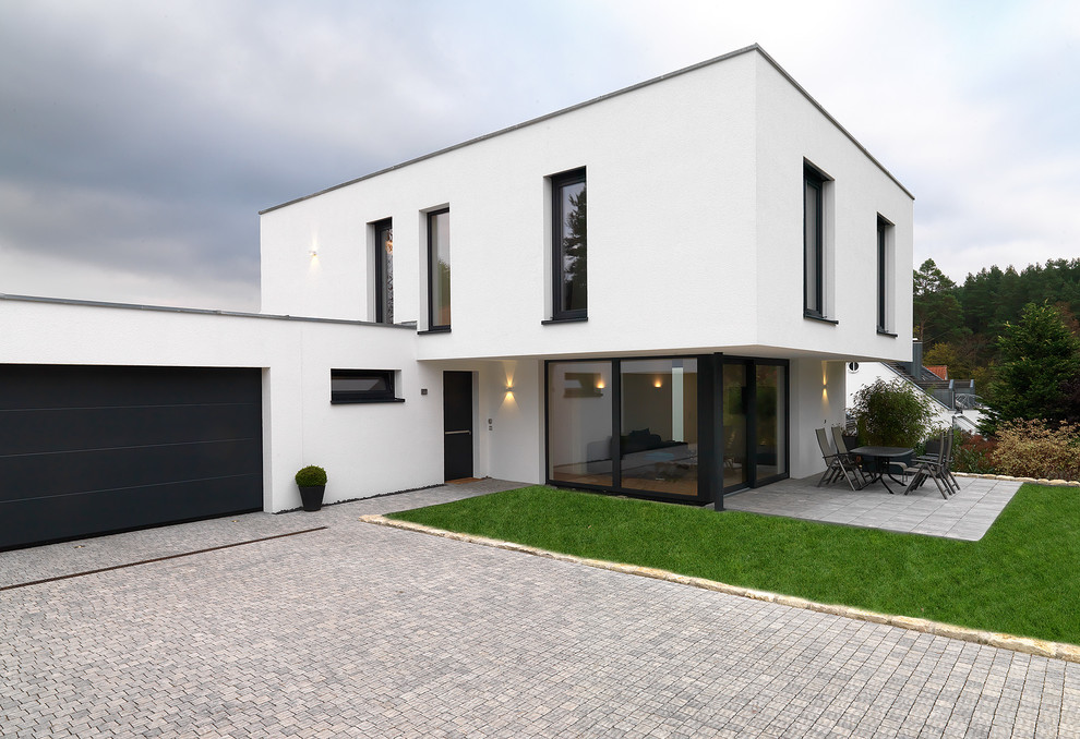 Design ideas for a mid-sized contemporary two-storey white exterior in Berlin with a flat roof.
