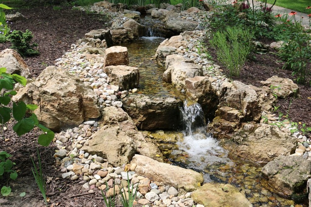 Inspiration for a large traditional backyard partial sun garden in Chicago with a water feature.