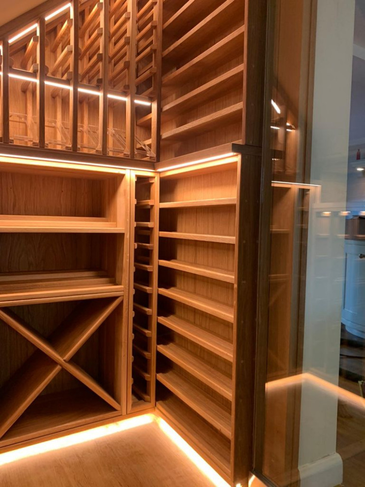 Small elegant dark wood floor and brown floor wine cellar photo in Other with storage racks