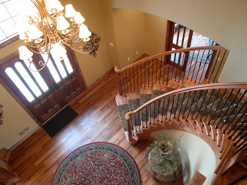Inspiration for a mid-sized traditional foyer in Milwaukee with beige walls, medium hardwood floors, a double front door and a medium wood front door.