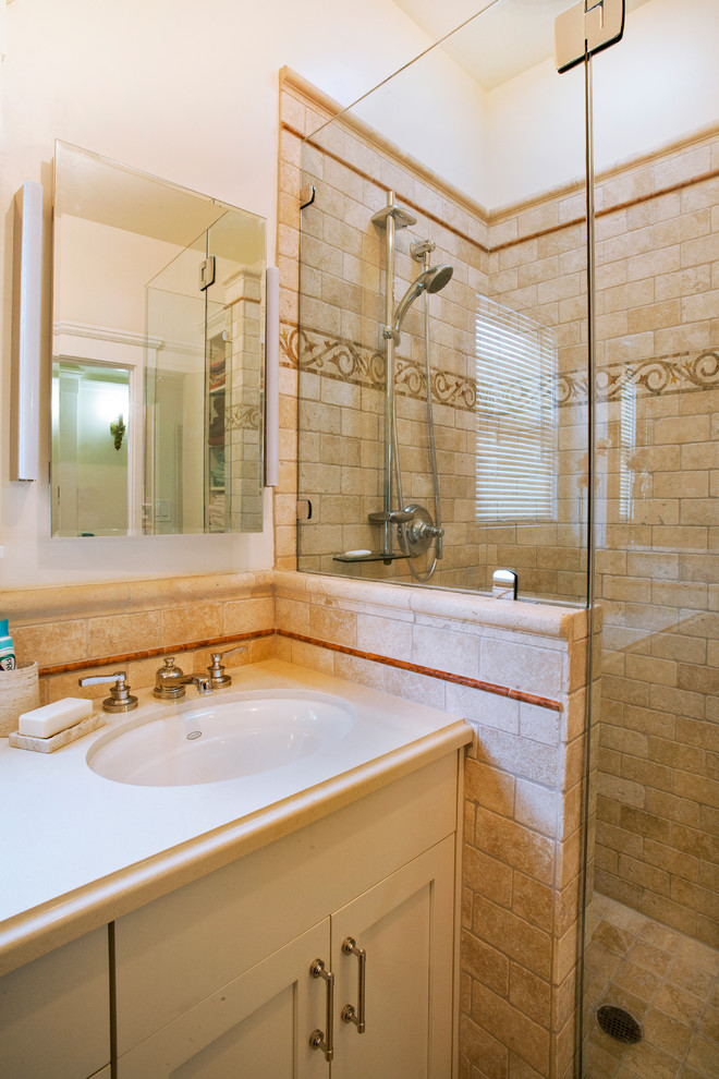 Photo of a small traditional master bathroom in San Francisco with an undermount sink, shaker cabinets, beige cabinets, quartzite benchtops, a corner shower, a one-piece toilet, beige tile, stone tile, beige walls, travertine floors, beige floor, a hinged shower door and beige benchtops.