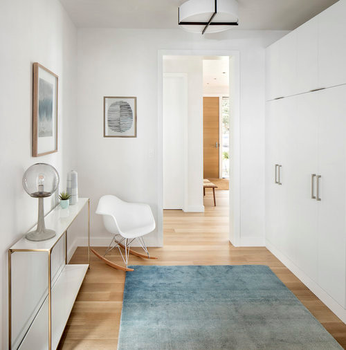 Hallway - mid-sized contemporary medium tone wood floor hallway idea in Denver with white walls