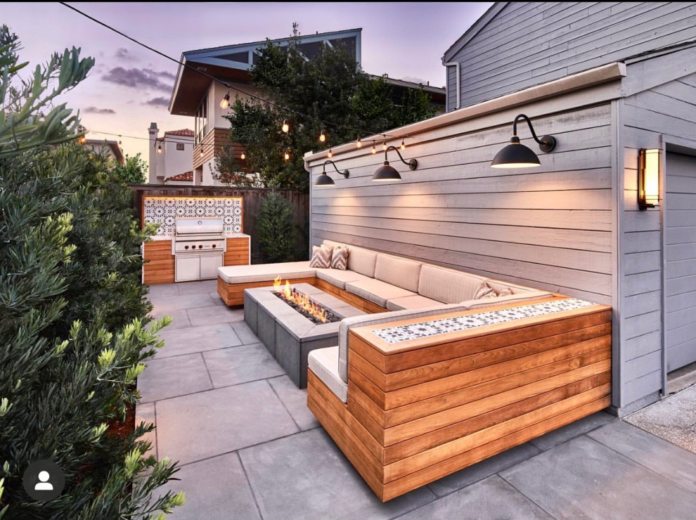 Idées déco pour une petite terrasse arrière bord de mer avec un foyer extérieur et des pavés en béton.