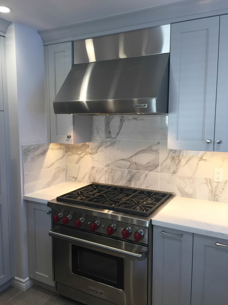 Mid-sized transitional u-shaped porcelain tile and gray floor eat-in kitchen photo in San Francisco with an undermount sink, recessed-panel cabinets, gray cabinets, quartz countertops, gray backsplash, porcelain backsplash, stainless steel appliances and white countertops