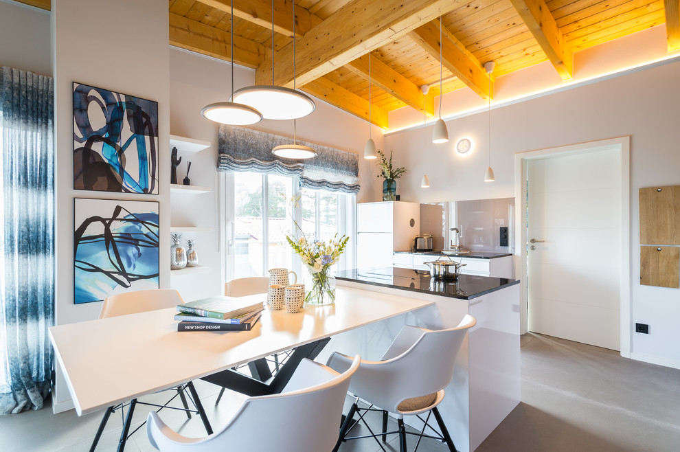 Expansive contemporary open plan dining in Hamburg with grey walls, ceramic floors, a ribbon fireplace, a metal fireplace surround and grey floor.