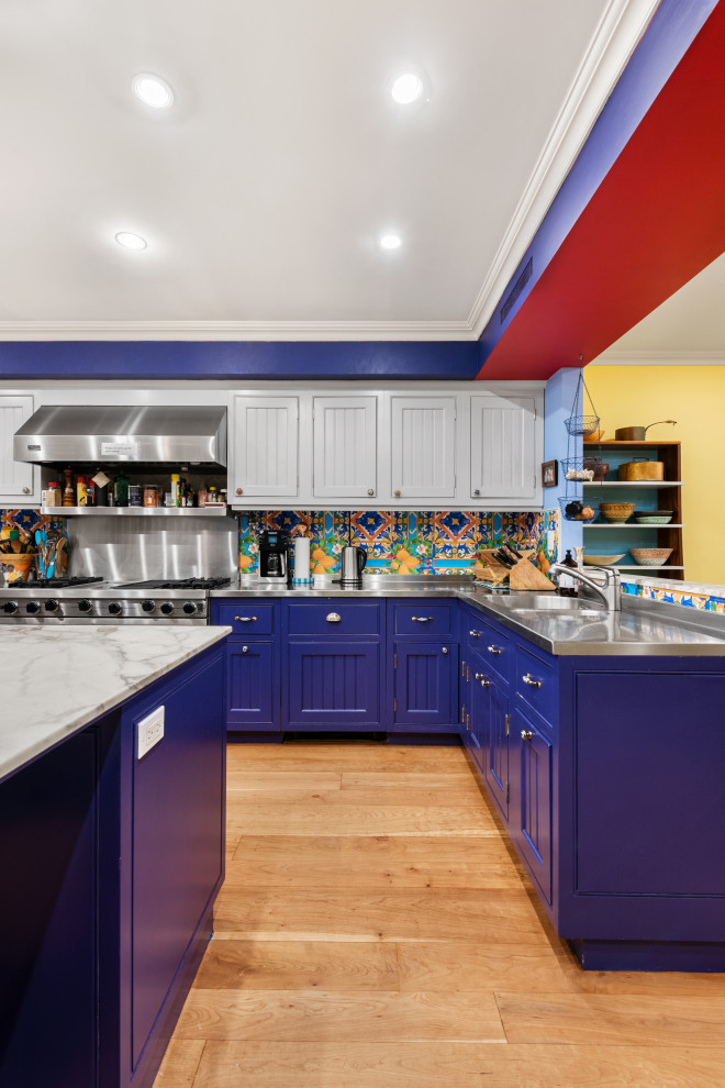 Large transitional u-shaped eat-in kitchen in New York with a drop-in sink, shaker cabinets, purple cabinets, marble benchtops, multi-coloured splashback, ceramic splashback, stainless steel appliances, light hardwood floors, with island, beige floor and grey benchtop.