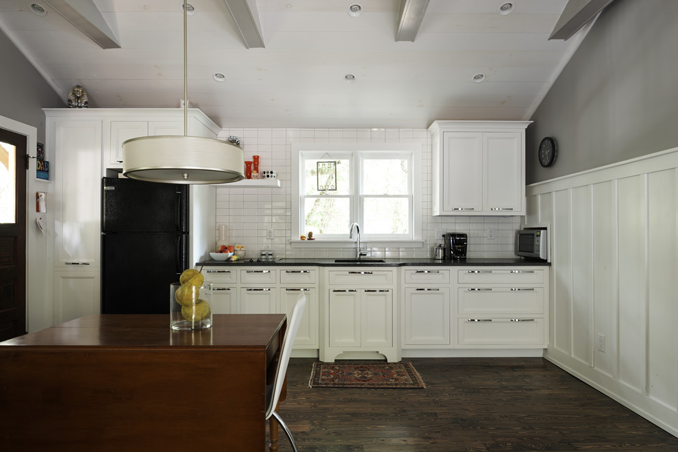 Eat-in kitchen - small transitional single-wall dark wood floor eat-in kitchen idea with an undermount sink, recessed-panel cabinets, white cabinets, granite countertops, white backsplash, subway tile backsplash, black appliances, no island and black countertops