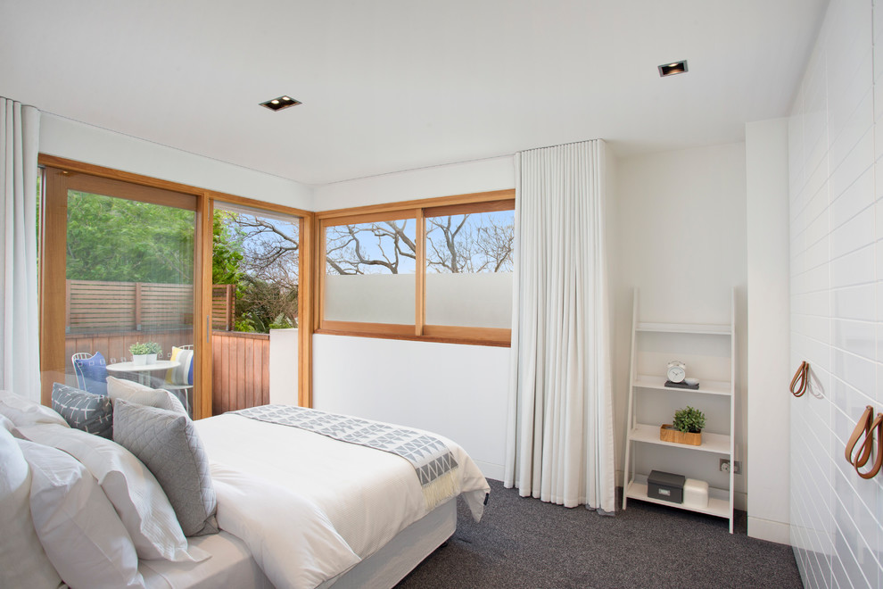 This is an example of a beach style guest bedroom in Sydney with white walls, carpet, no fireplace and grey floor.