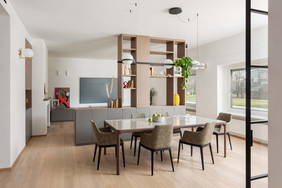 Inspiration for a large contemporary open plan dining in Milan with white walls, painted wood floors, a standard fireplace, a metal fireplace surround and beige floor.