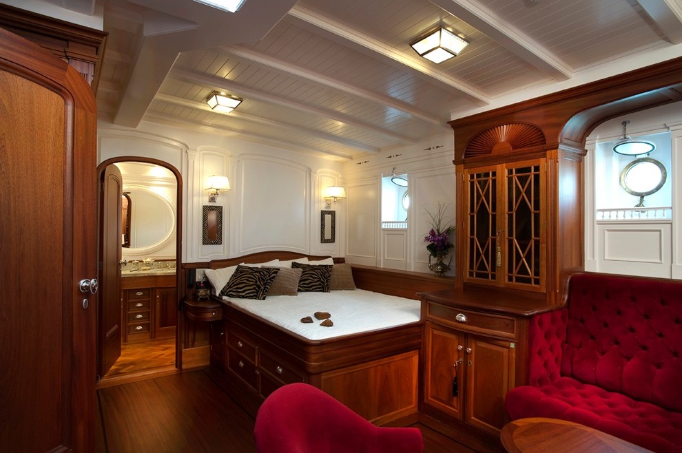 This is an example of a traditional bedroom in Sydney with white walls, dark hardwood floors and no fireplace.