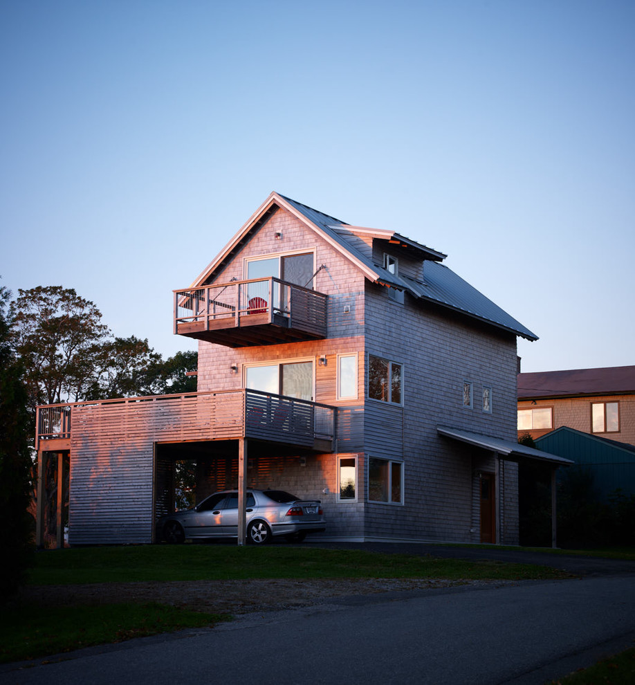 This is an example of a beach style three-storey brown house exterior in Portland Maine with wood siding, a gable roof and a metal roof.