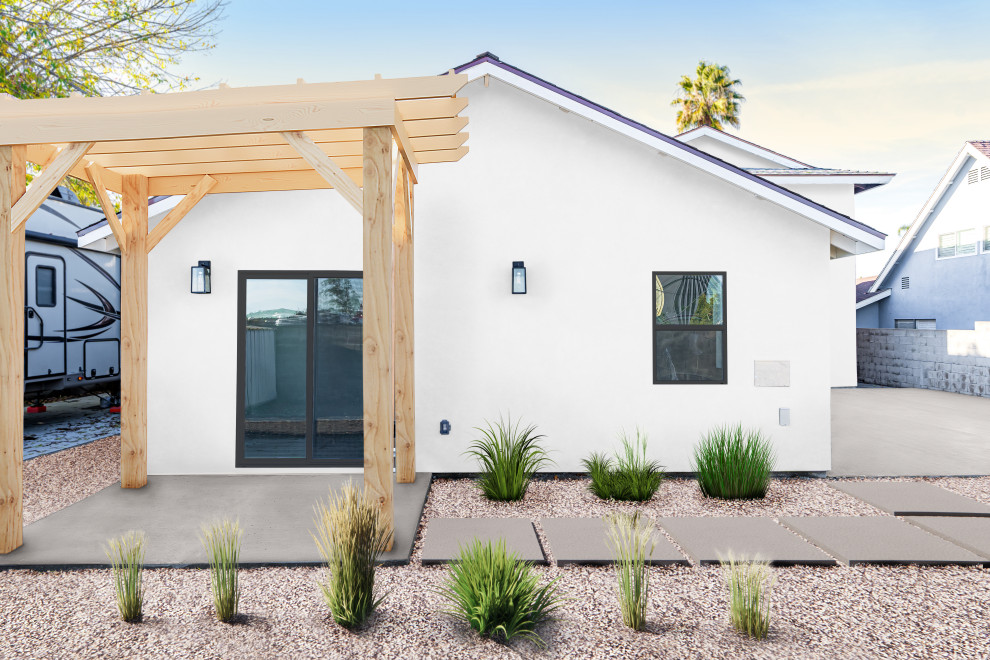 Foto della micro casa bianca contemporanea a un piano di medie dimensioni con rivestimento in mattoni, tetto a capanna, copertura a scandole, tetto nero e con scandole