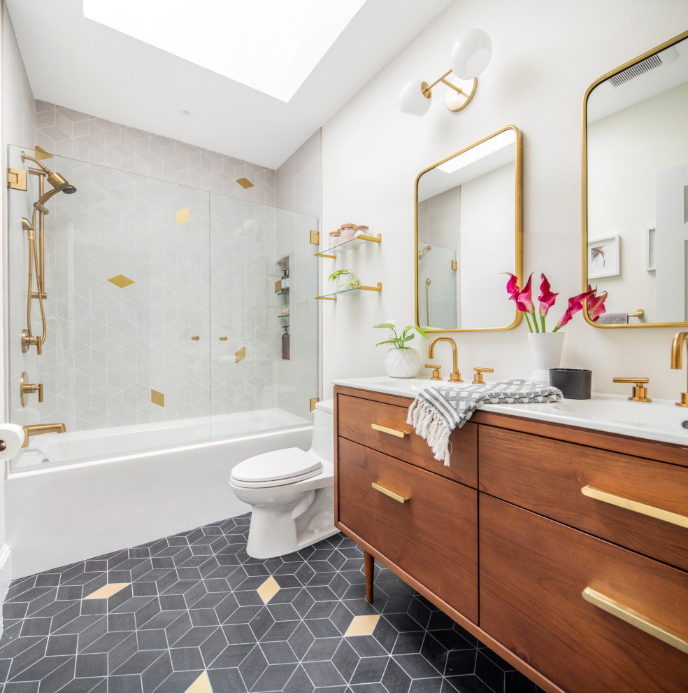 Photo of a contemporary master bathroom in DC Metro with medium wood cabinets, a drop-in tub, an alcove shower, a one-piece toilet, gray tile, ceramic tile, white walls, ceramic floors, an integrated sink, marble benchtops, grey floor, white benchtops, a niche, a double vanity and a freestanding vanity.
