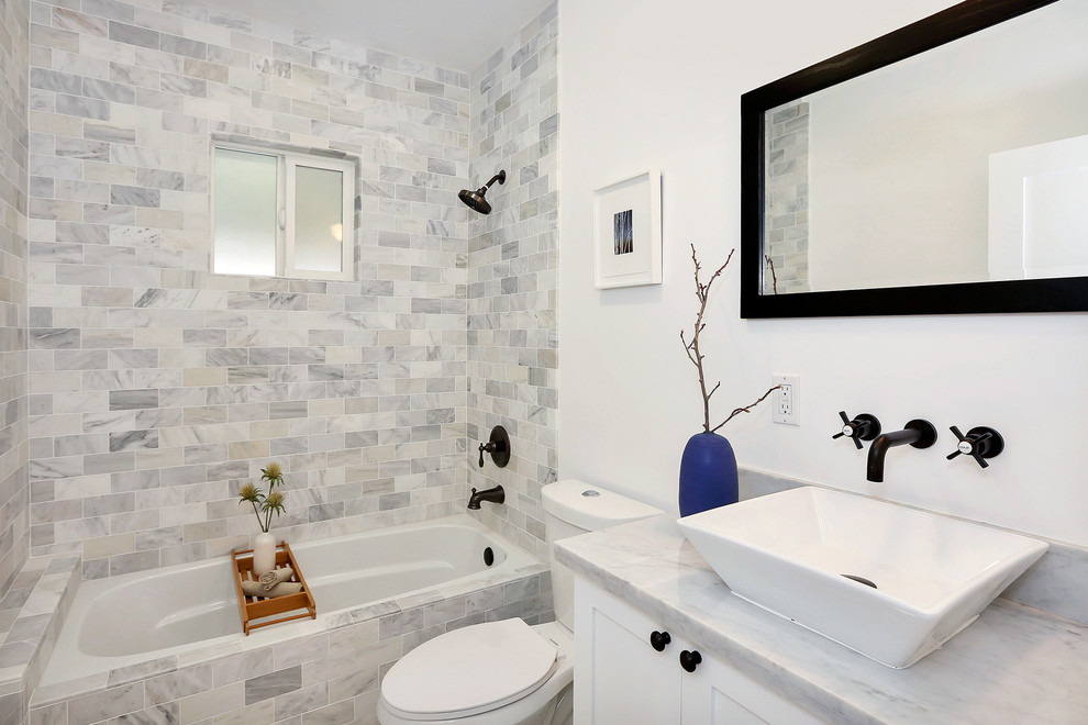 Inspiration for a transitional gray tile alcove bathtub remodel in Los Angeles with a vessel sink, shaker cabinets, white cabinets and a two-piece toilet