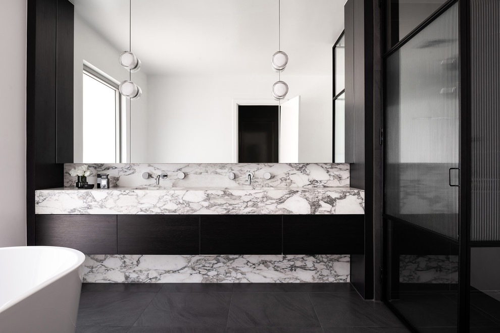 Design ideas for a large contemporary master wet room bathroom in Melbourne with flat-panel cabinets, black cabinets, a freestanding tub, a one-piece toilet, gray tile, ceramic tile, white walls, ceramic floors, an undermount sink, marble benchtops, grey floor, a hinged shower door and multi-coloured benchtops.