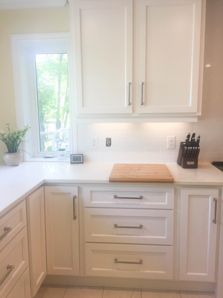 Mid-sized transitional u-shaped porcelain tile and gray floor eat-in kitchen photo with an undermount sink, shaker cabinets, white cabinets, quartz countertops, white backsplash, subway tile backsplash, stainless steel appliances, a peninsula and beige countertops