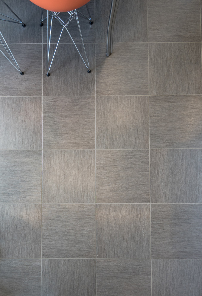 Example of a large minimalist l-shaped eat-in kitchen design in St Louis with an undermount sink, flat-panel cabinets, white cabinets, quartz countertops, blue backsplash, glass tile backsplash, white appliances and a peninsula