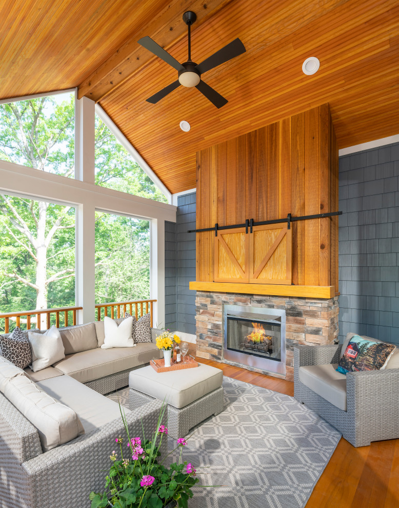 Inspiration for a mid-sized transitional sunroom in Detroit with medium hardwood floors, a standard fireplace, a stone fireplace surround, a standard ceiling and beige floor.