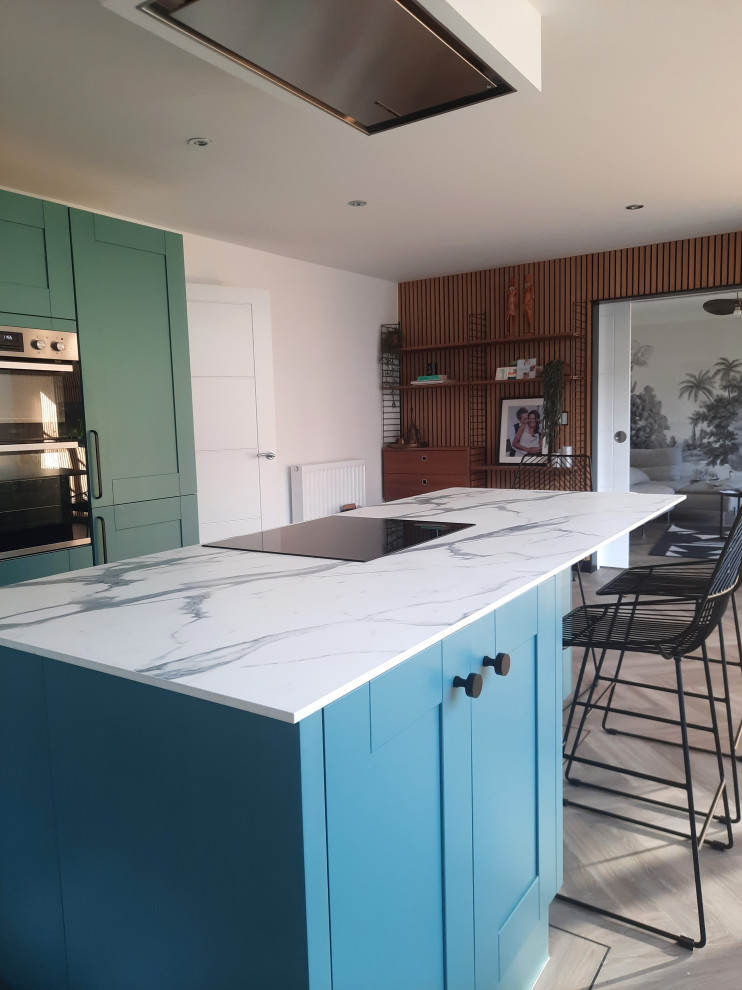 Medium sized scandi kitchen in West Midlands with shaker cabinets, laminate countertops, vinyl flooring and an island.