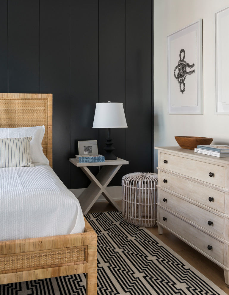 Inspiration for a coastal medium tone wood floor and brown floor bedroom remodel with black walls