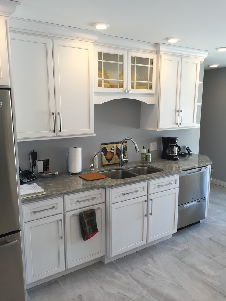 Eat-in kitchen - large transitional l-shaped porcelain tile and gray floor eat-in kitchen idea with an undermount sink, shaker cabinets, white cabinets, granite countertops, stainless steel appliances and no island